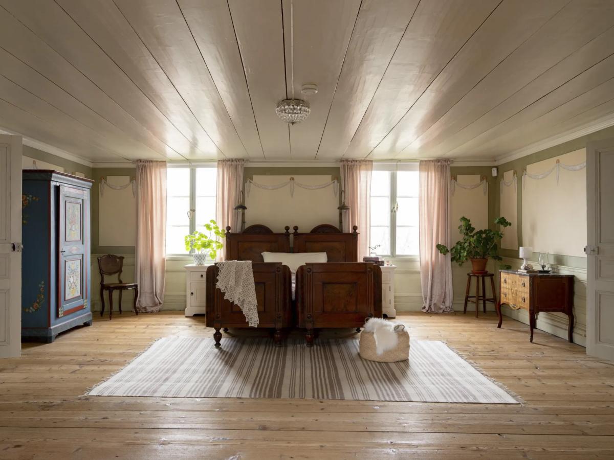 Spacious bedroom with white wooden ceilings