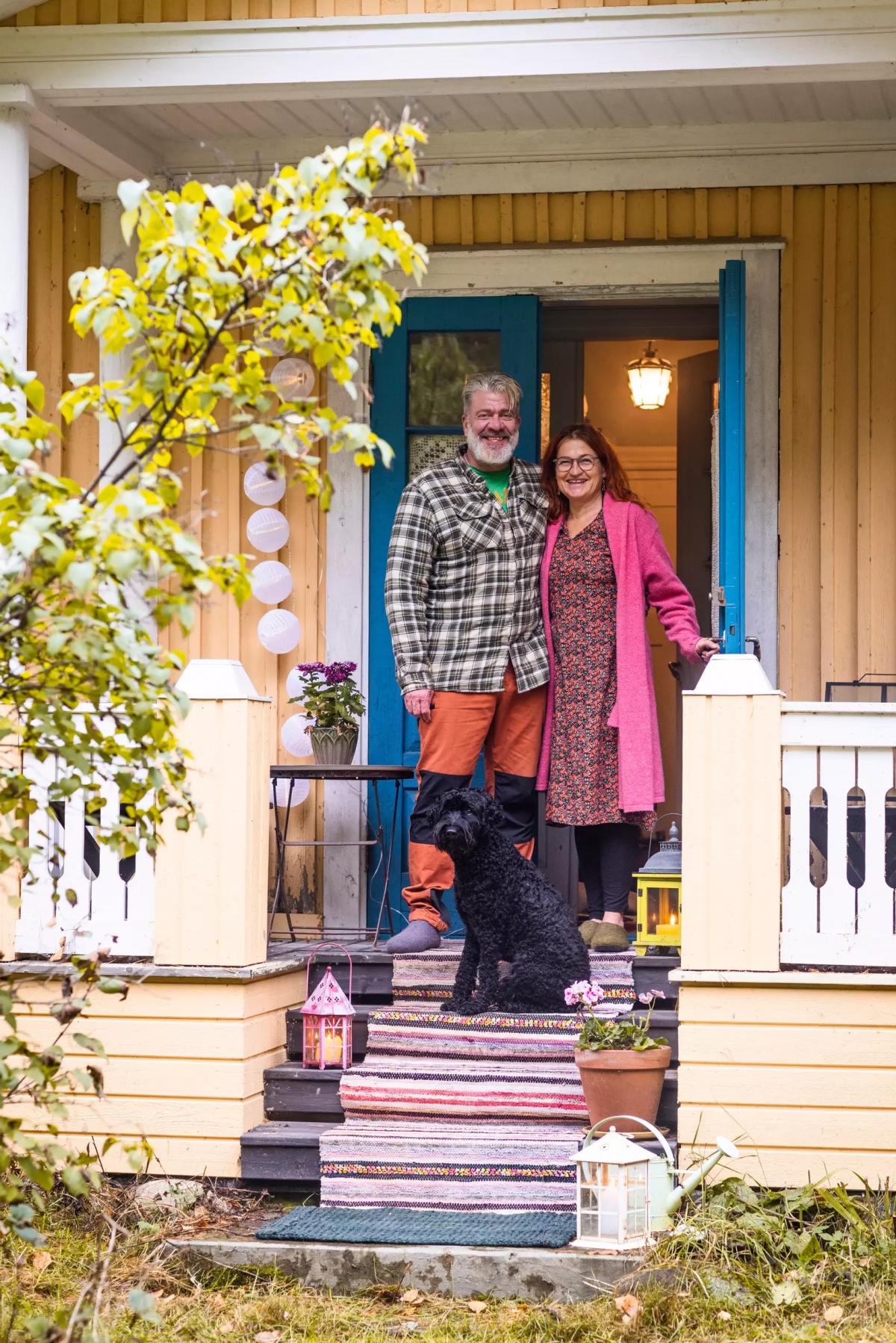 Ilkka Peräoja and Arja Heinilä with their dog on the doorstep of their home