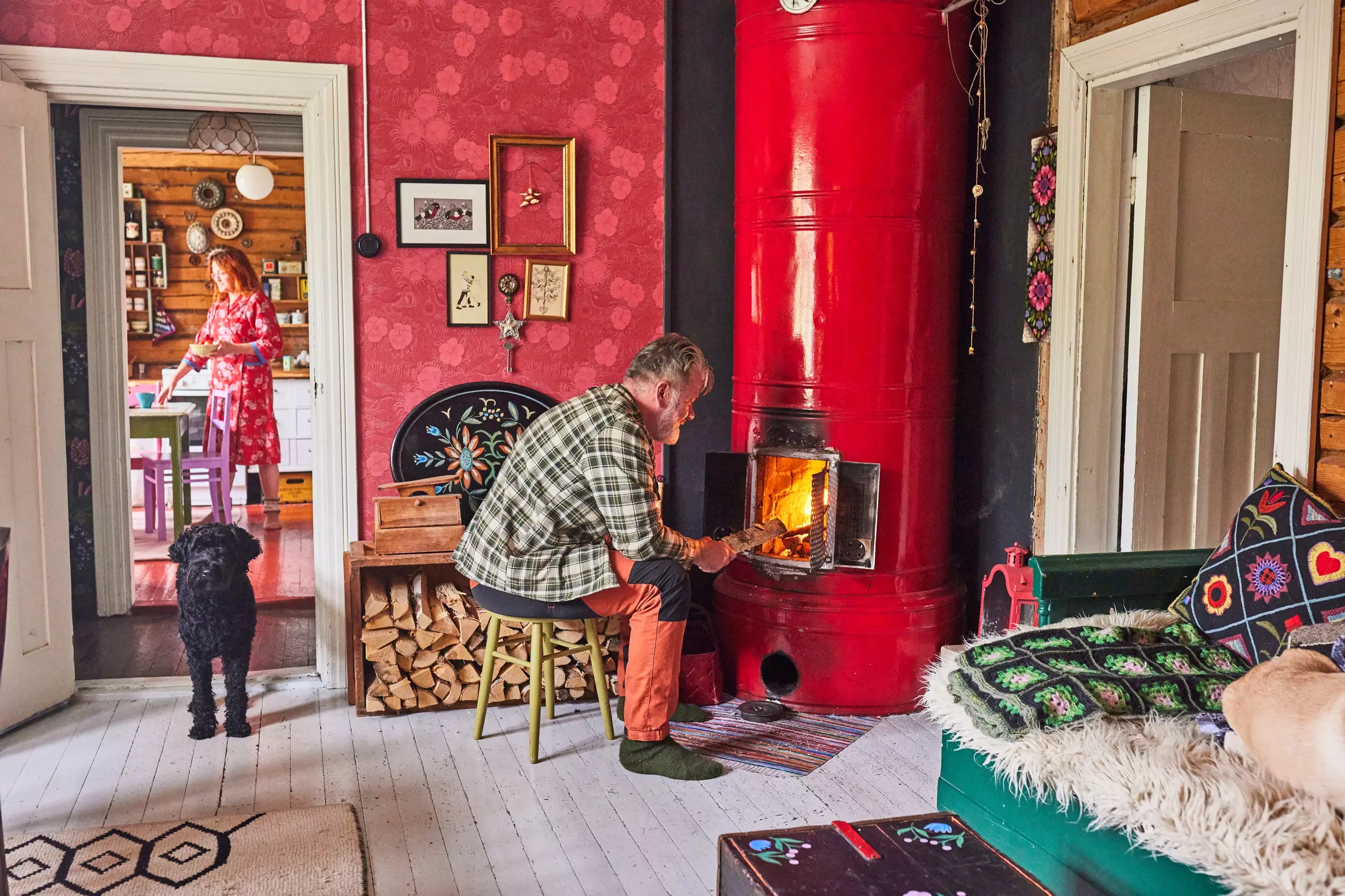 A bright red stove in the living room with red wallpaper in a Finnish home